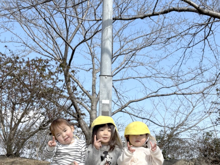 外でポーズをとる園児の写真