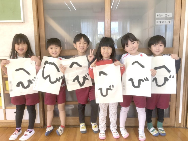 習字を見せる園児の写真