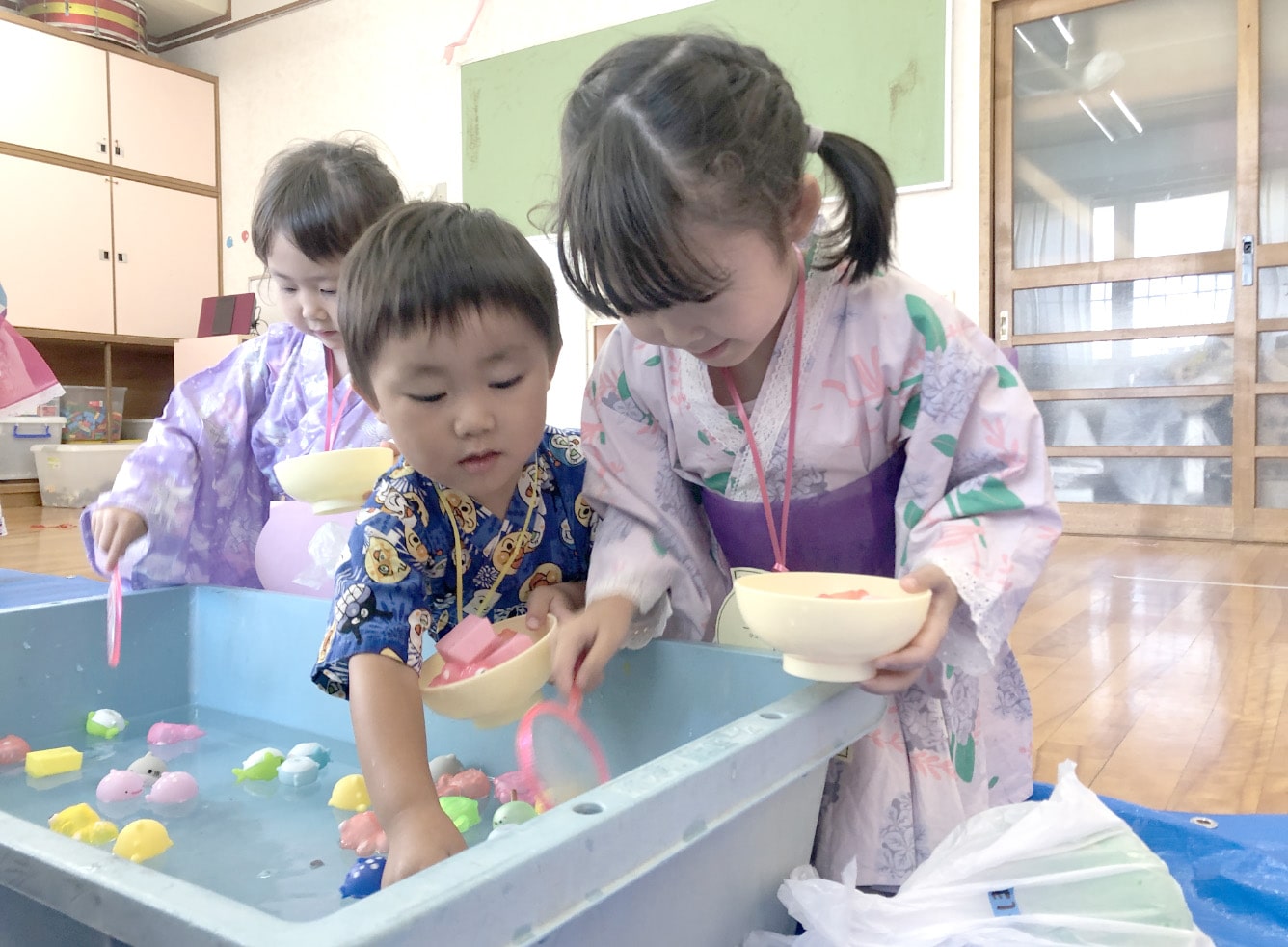 ボールをすくう浴衣の子どもたちの写真