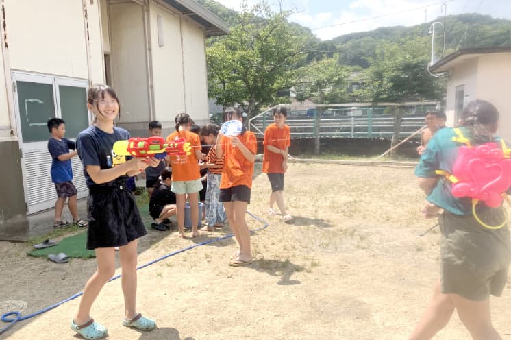 水鉄砲で遊ぶ子どもの写真
