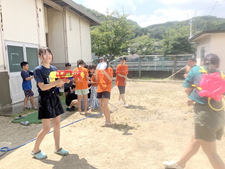 水鉄砲で遊ぶ子どもの写真
