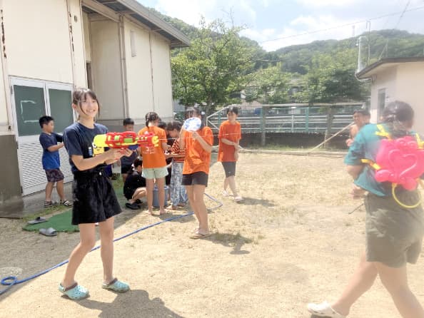 水鉄砲で遊ぶ子どもの写真