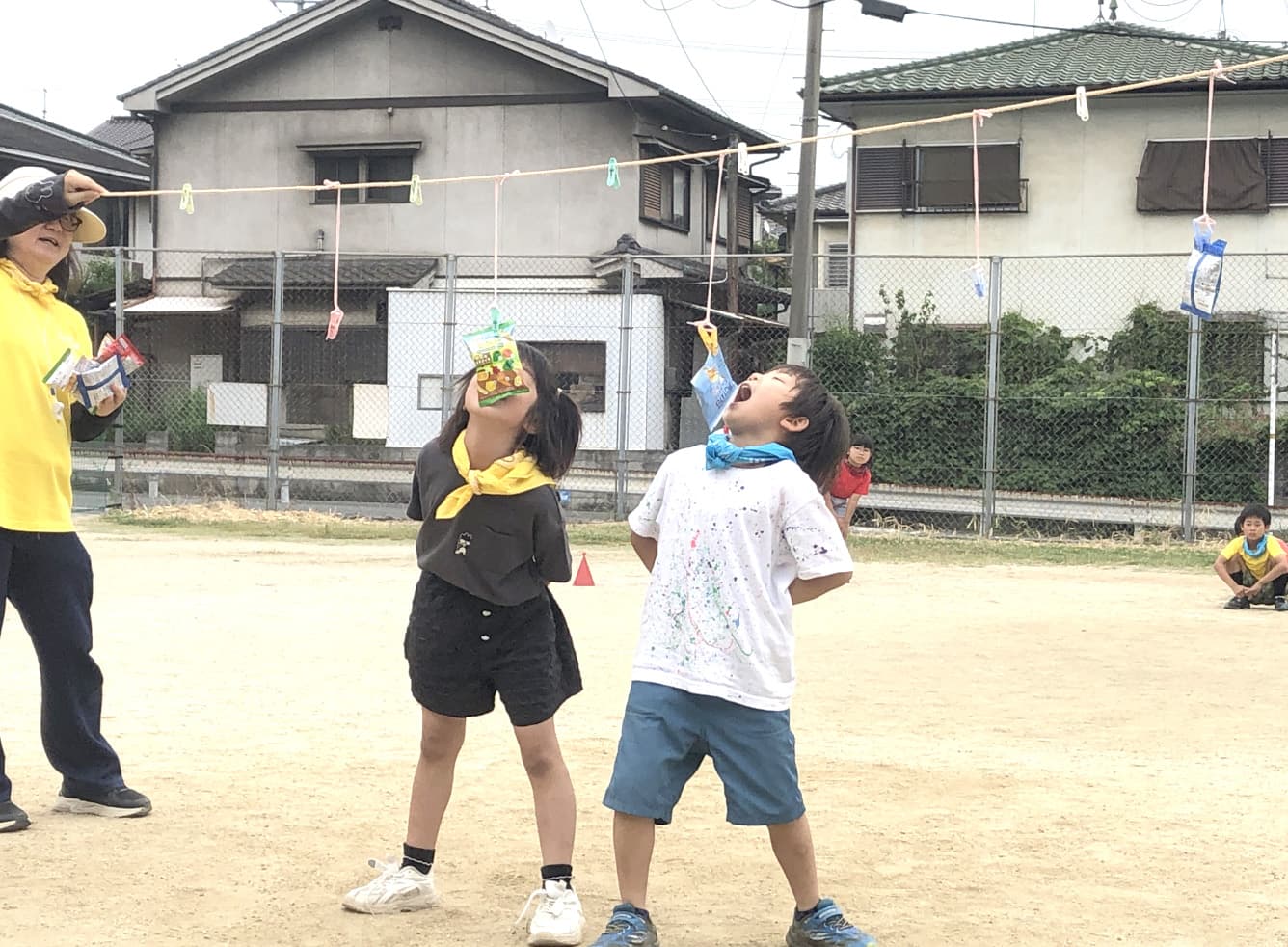 パン食い競争をする子どもの写真