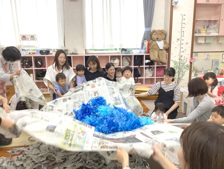 新聞紙で遊んでいる親子