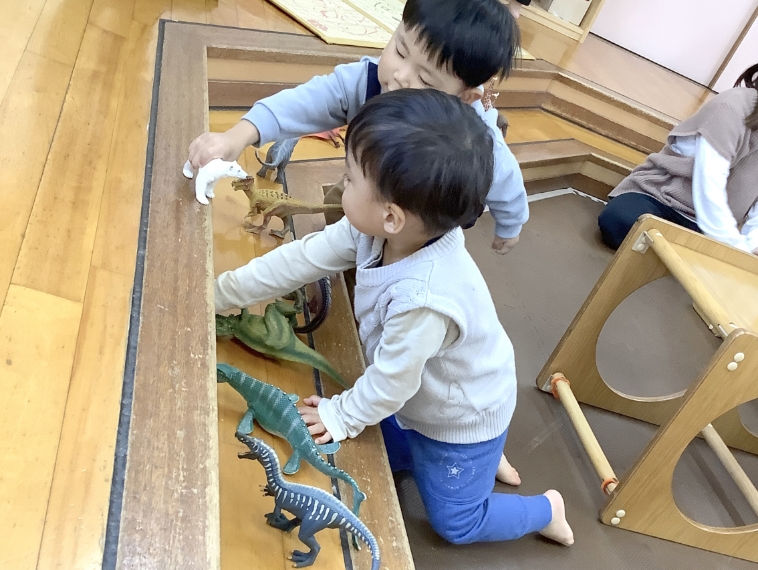 恐竜のおもちゃで遊ぶ子どもの写真