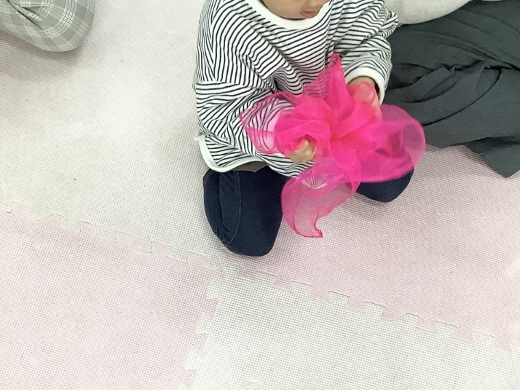 薄い布で遊ぶ子どもの写真