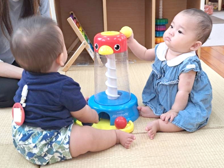 二人の赤ちゃんが見つめあっている様子