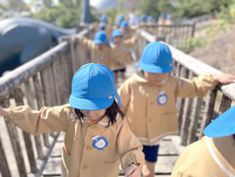 遊具の端を渡る園児の写真