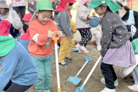 スコップで遊ぶ園児の写真